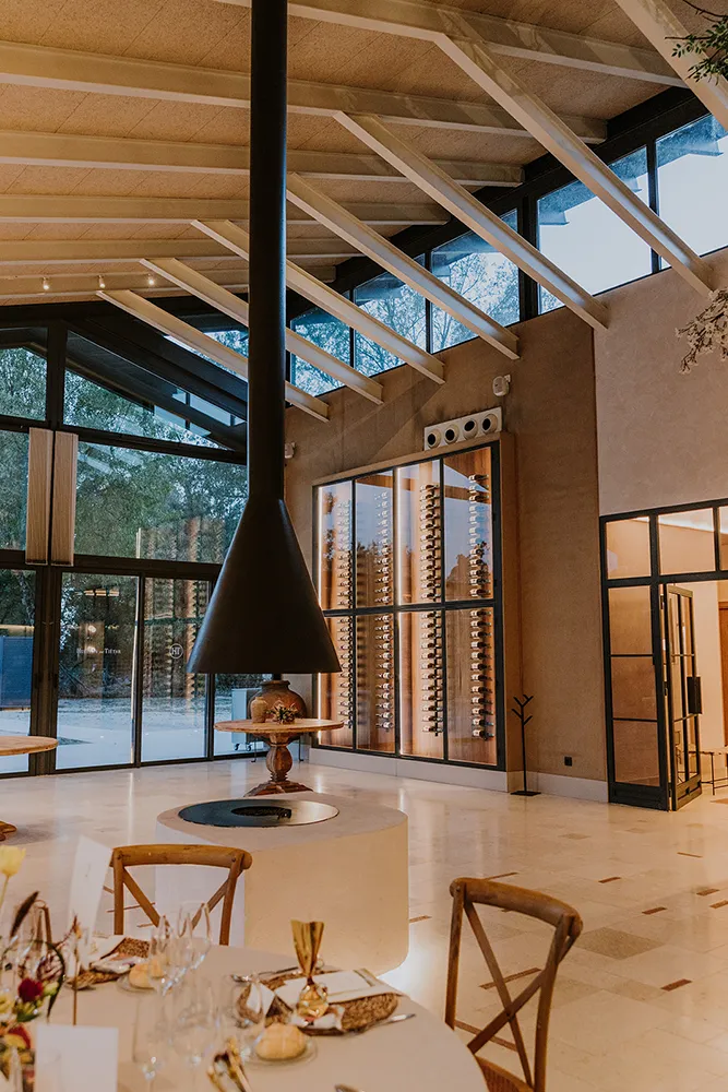 Salón de Huellas del Tiétar: iluminación cálida, gran chimenea y vinoteca al fondo. Lanzahíta, Ávila