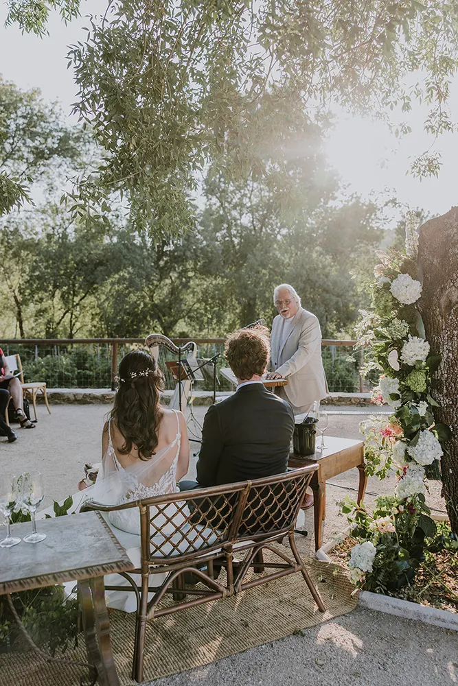 Ceremony at golden hour at Huellas del Tiétar: couple at the outdoor space, Sierra de Gredos in the background, warm light. Lanzahíta