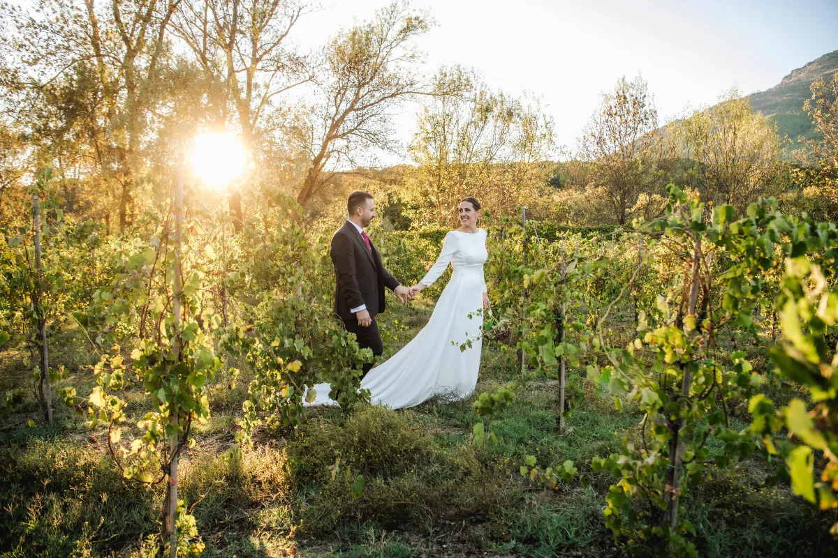 A couple walking through a vineyard on their Wedding day in Spain
